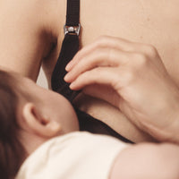 Close up of woman unclasping a nursing bra to nurse her child to